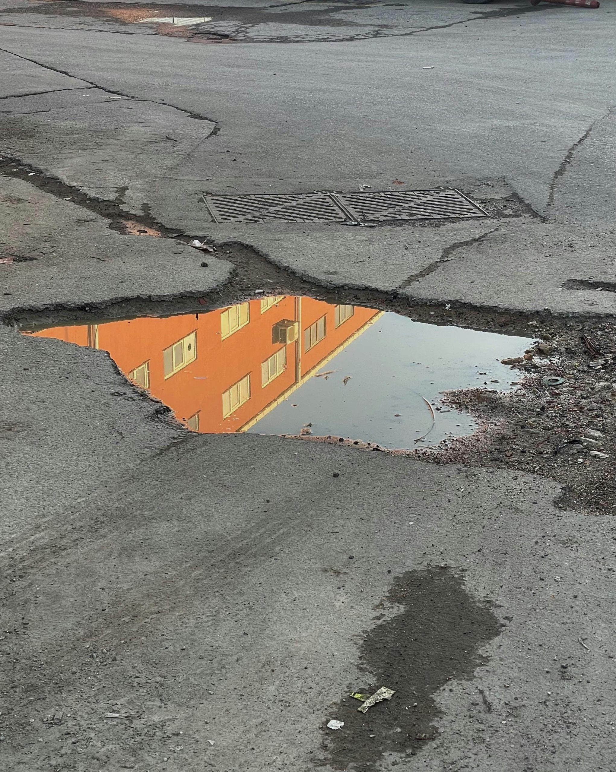 A picture of a large pothole filled with water